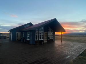 a small building with a sunset in the background at Myrarkot Country Home in Selfoss