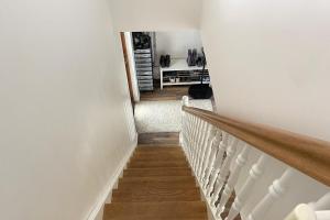 a hallway with a staircase with white walls and wooden floors at Myrarkot Country Home in Selfoss