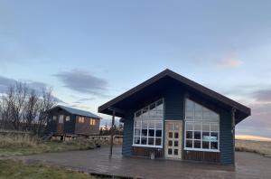 a small blue building with a large window at Myrarkot Country Home in Selfoss