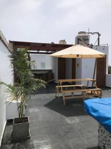 a patio with a table and an umbrella at Casa con piscina-Wifi alta velocidad in Lima