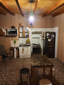 Il comprend une cuisine équipée d'un réfrigérateur et d'une table. dans l'établissement Las Casas Hostel Atacama, à San Pedro de Atacama
