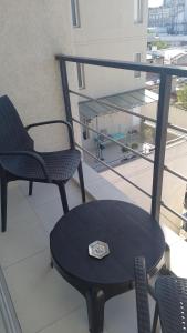 a table and chairs on a balcony with a clock on it at PLAZA376 2 in Chivilcoy