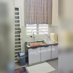a kitchen with a sink and a window at RizQ Homestay Tg Malim in Kerling