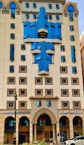 Hayah Grand Hotel في المدينة المنورة: مبنى كبير عليه نوافذ زرقاء