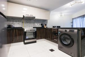 a kitchen with a washer and a washing machine at Elite LUX Holiday Homes - Modern One Bedroom Apartment in MAG 5, Dubai South in Dubai