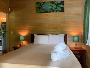 a bedroom with a bed with two towels on it at Ocean Melody 2 in Uvita