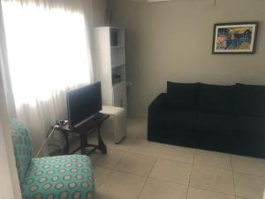 sala de estar con sofá negro y silla en JN Monoambiente en Salta