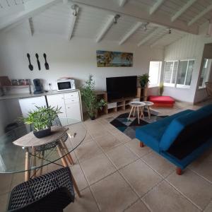 uma sala de estar com um sofá azul e uma mesa em Lauraym2 em Baie-Mahault
