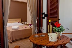 a room with a bed and a table with wine glasses at Calm View in Vasiliki