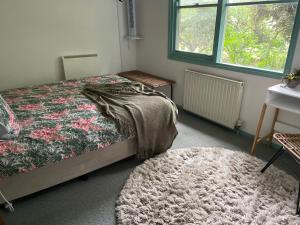 a bedroom with a bed and a rug at Butlers Guesthouse in Birregurra