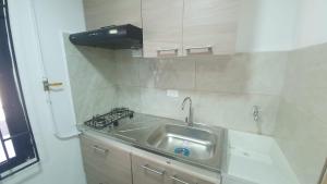 uma cozinha com um lavatório e um fogão em Pequeño apartaestudio em Medellín