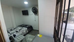 Habitación pequeña con cama y ventilador. en Pequeño apartaestudio, en Medellín
