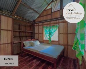 Bett in einem Holzzimmer mit Fenster in der Unterkunft Cafe Sabang Guest House in Sabang