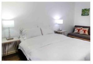 1 dormitorio con 1 cama blanca y 2 lámparas en Confortable apartamento con la perfecta ubicación!, en Bogotá