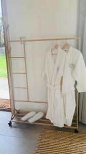 a clothes rack with white robes and towels on it at Cabaña Romántica in Cunco