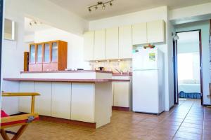 uma cozinha com armários brancos e um frigorífico branco em Ocean View, Playas del Caribe em Cabo Rojo