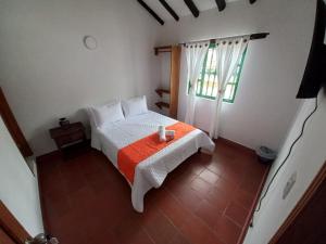 um pequeno quarto com uma cama e uma janela em Oasis san José de la villa em Villa de Leyva