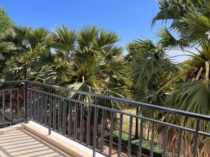 a balcony with palm trees in the background at SSK Apartment in Siem Reap