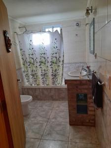 een badkamer met een wastafel, een toilet en een douchegordijn bij Sueño Bonito in San Andrés de Giles