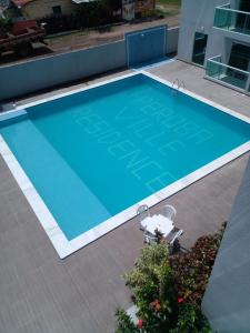 una vista aérea de una gran piscina azul en Maragogi , Peroba Ville Apartamento com piscina, en Maragogi