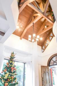 a christmas tree in a living room with a wooden ceiling at El Castillo Bed and Breakfast in Angono