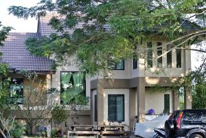 a building with a car parked in front of it at Jamjuree Garden in Ban Thung Ma Nieo