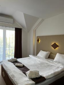 una camera da letto con un grande letto con asciugamani di Hotel Andalus a Skopje