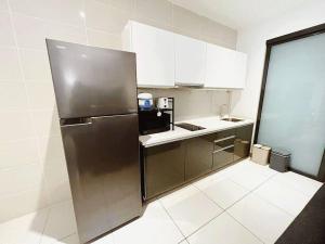 a kitchen with a stainless steel refrigerator and white cabinets at PROMO Connected train 2 Bedroom (ABOVE MALL) 20 in Kuala Lumpur