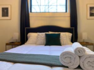 1 dormitorio con 1 cama con toallas en Stylish Downtown Kingsville Getaway with Putting Green, Firepit & Games en Kingsville