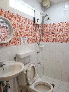 a bathroom with a toilet and a sink and a shower at La Vida Hostel Samal Island in Samal