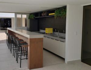 a kitchen with a counter with stools in it at Flat beira mar do Cabo Branco in João Pessoa