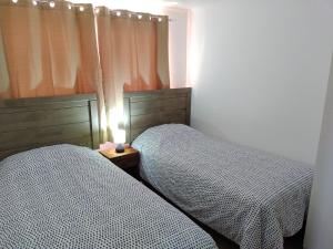 dwa łóżka siedzące obok siebie w sypialni w obiekcie DepartoCasa2 Premium w mieście Arica