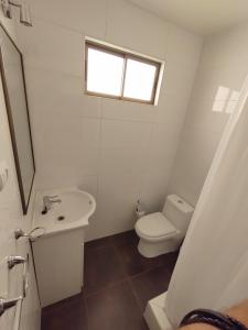 a bathroom with a toilet and a sink and a window at CASA PREMIUM Estadio Carlos Dittborn in Arica +22 photos