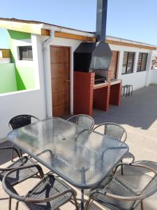 a glass table and chairs on a patio at DepartoCasa2 Premium in Arica