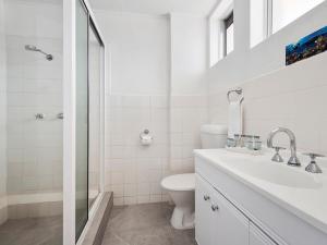 a white bathroom with a toilet and a shower at The Robert Towns in Townsville