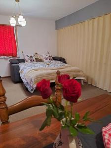 een slaapkamer met een bed met rozen in een vaas bij Vacances en tout tranquillité à Vercorin in Vercorin