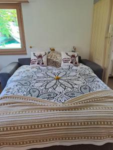 een slaapkamer met een groot bed met een deken erop bij Vacances en tout tranquillité à Vercorin in Vercorin