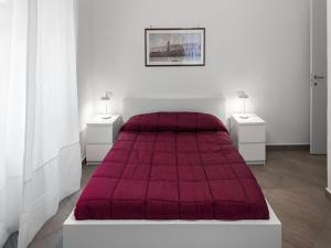 ナポリにあるBed & Breakfast Nilo32の白い部屋の赤いベッド1台(ナイトスタンド2台付)