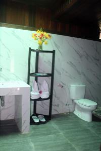 La salle de bains est pourvue de toilettes et d'une étagère avec des chaussures. dans l'établissement Amoryg Resort and Dive Raja Ampat, à Pulau Mansuar