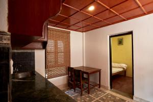 a kitchen with a table and a sink in a room at Bandipur Bliss-Apartment in Bandipur +2 photos