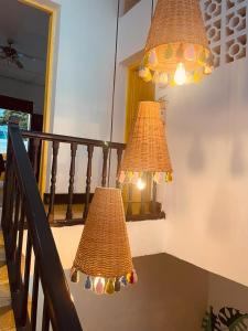 two chandeliers hanging from a staircase with a railing at Hostal 1545 in Ríohacha