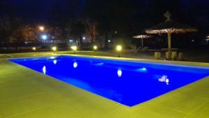 - une grande piscine bleue la nuit dans l'établissement Cabañas La Deseada (Ranchos, Buenos Aires), à Ranchos