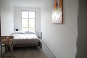 a white bedroom with a bed and a window at A L'ill - Apparts & Studios Strasbourg Hyper Centre in Strasbourg