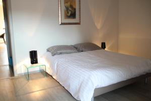 - une chambre avec un lit blanc et une table de nuit dans l'établissement A L'ill - Apparts & Studios Strasbourg Hyper Centre, à Strasbourg