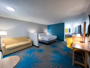 a hotel room with a bed and a couch at Days Inn & Suites by Wyndham Santa Rosa, NM in Santa Rosa