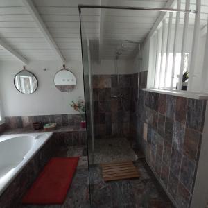 a bathroom with a shower and a tub and a sink at Lauraym2 in Baie-Mahault