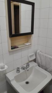 a white bathroom with a sink and a mirror at Habitación con baño privado Un piso por escalera in Buenos Aires