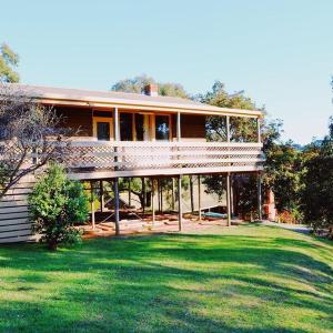 uma casa grande num campo com um relvado verde em Iluka Retreat Glamping Village em Red Hill South