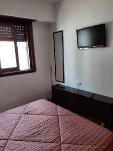 um quarto com uma cama e uma televisão na parede em Hernandez vista al mar em San Bernardo