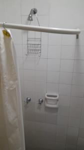uma casa de banho com uma cortina de chuveiro e uma cabeça de chuveiro em Habitación con baño privado Un piso por escalera em Buenos Aires